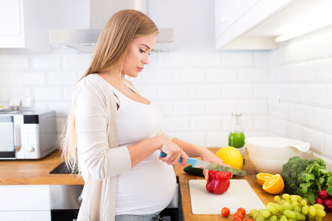pregnant woman preparing dinner